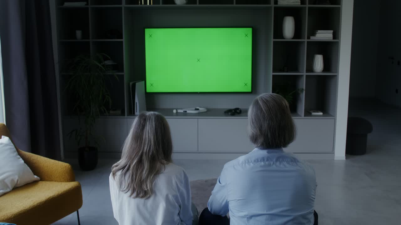 Persone che guardano la TV con green screen