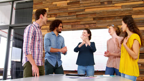 Business-executives-giving-high-fives-while-working-in-office