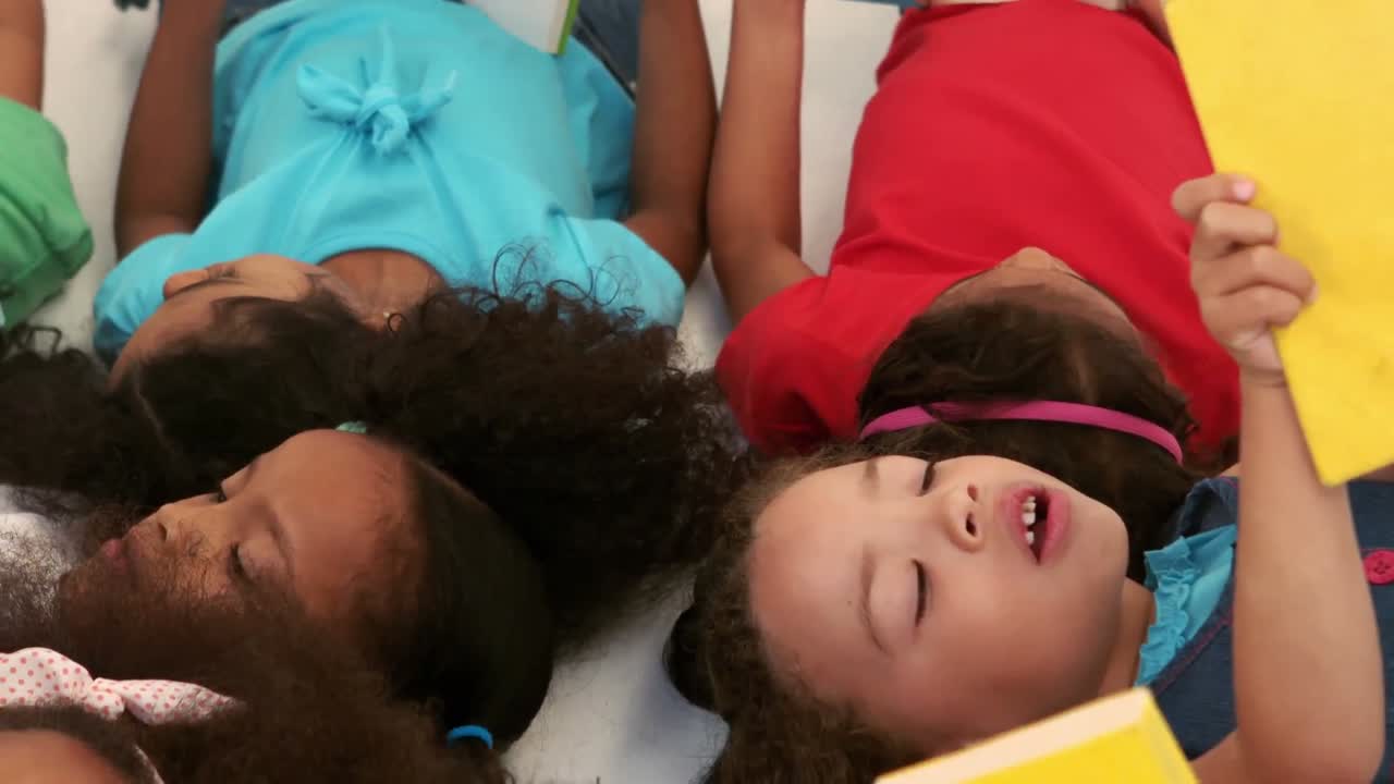 un pequeño grupo de niños acostados y leyendo libros