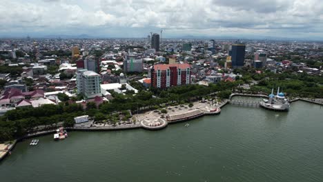 vista aérea de la ciudad de makassar sulawesi indonesia en un día soleado a lo largo del agua con una mezquita en la distancia