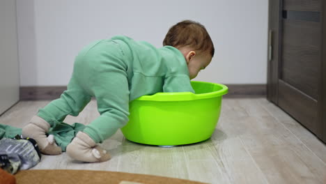 toddler plays with a laundry basin