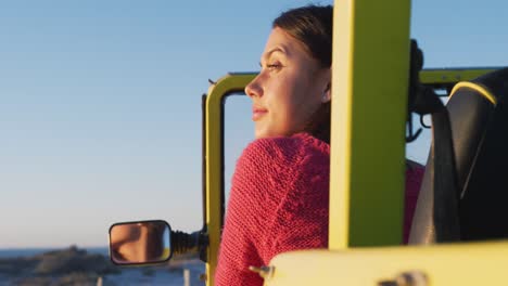 Feliz-Mujer-Caucásica-Sentada-En-Un-Buggy-De-Playa-Junto-Al-Mar