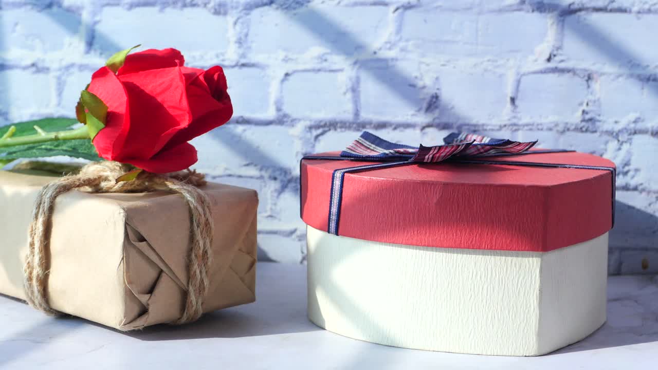 caja de regalos y rosa