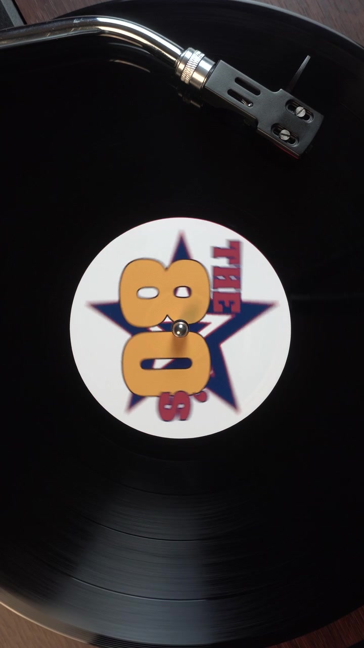 Lodret billede: En vinylplade begynder at afspille en 80'er musiksamling fyldt med årtiets største hits.
