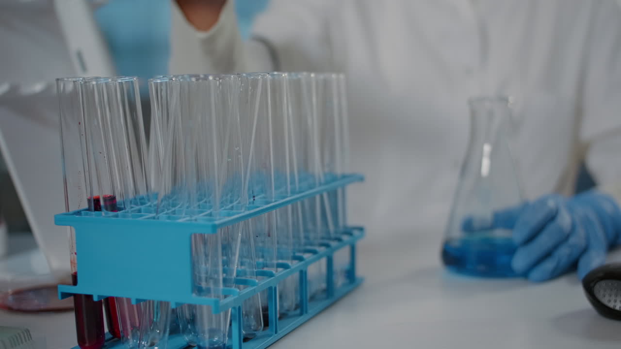 Biologist using micro pipette to mix substance in beaker and test tube