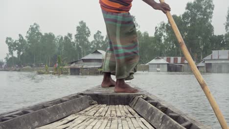 barquero remando un bote hacia la casa inundada