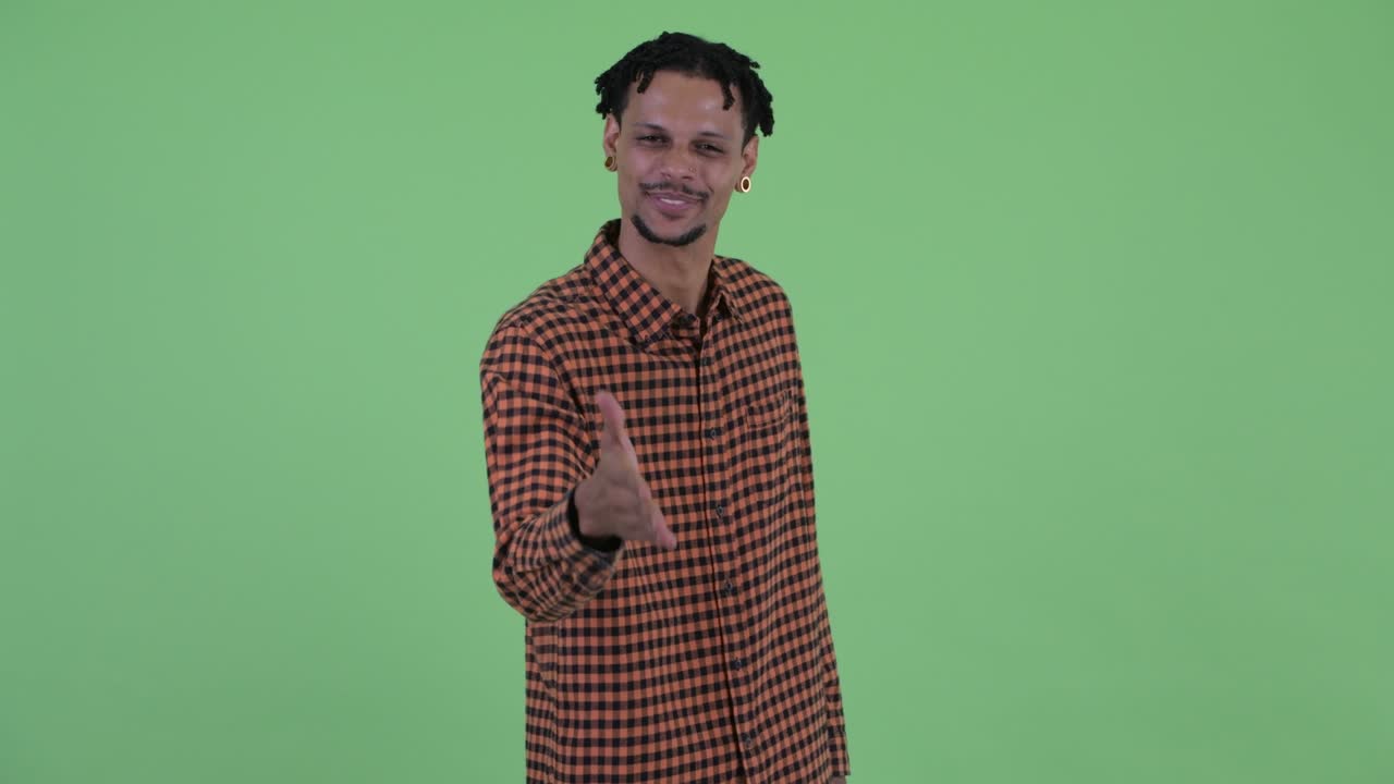 Giovane uomo africano felice e bello con i dreadlock.
