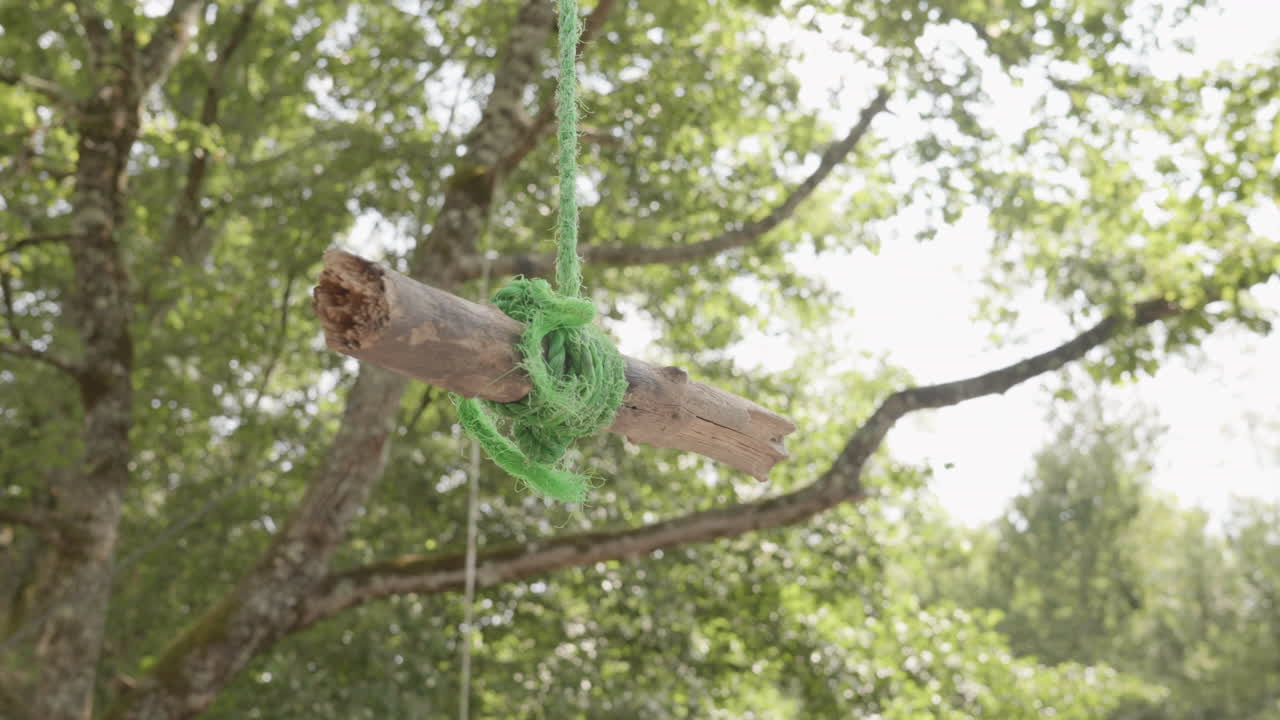 pequeño tronco de madera colgando de la cuerda en la naturaleza