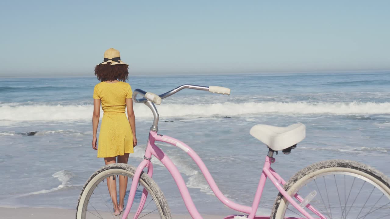 아프리카계 미국인 여성 이 앞면 에 자전거 를 타고 바 ⁇ 가 를  ⁇ 고 있다