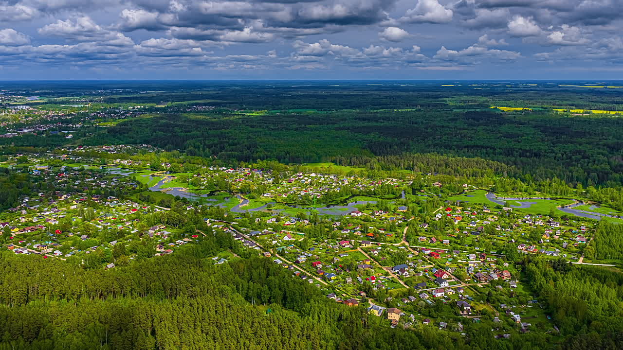 Drone hyperlapse of Jelgava city with meandering Svete river and moving clouds from above
