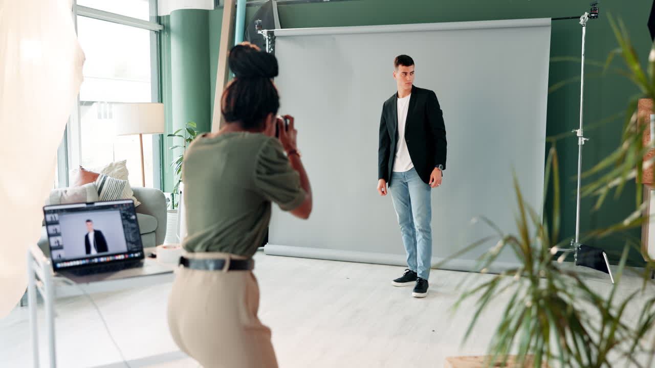 A photographer taking pictures of a male model in a studio
