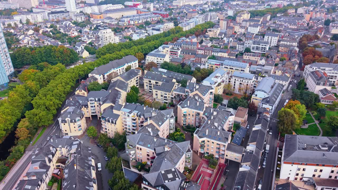 Drone shot moving forward above Chézy district in Rennes, showing buildings, streets and the Ille-et-Rance canal lined with trees