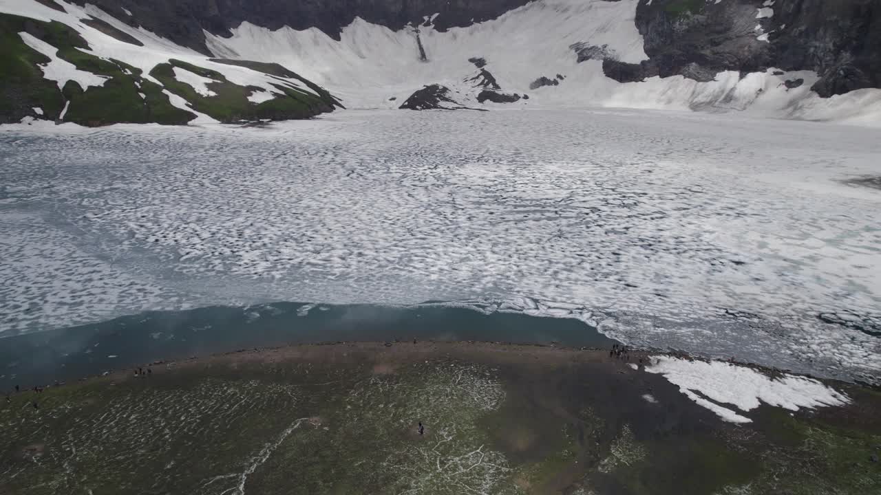 얼어붙은 라티 갈리 호수, 눈으로 인 절벽과 초록색 알프스 풍경으로 둘러싸여