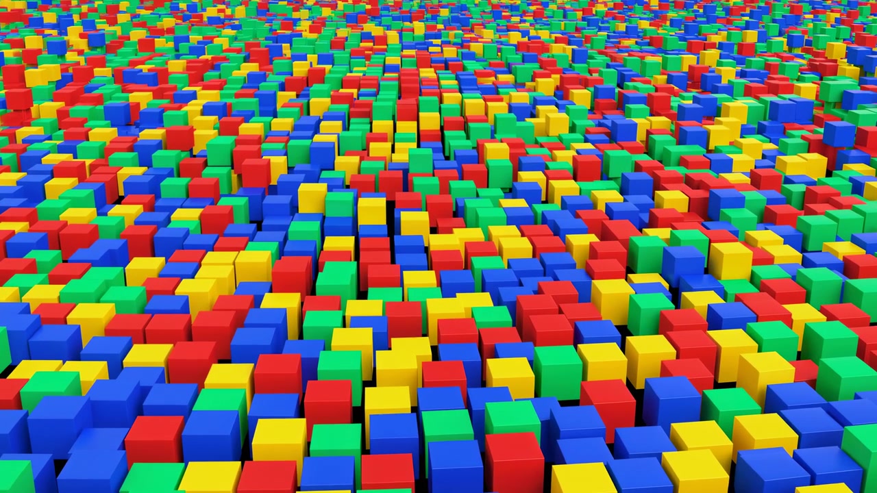 A dense arrangement of small colorful cubes fills the frame from an elevated viewpoint, creating a narrow central corridor that adds depth and direction. Bright red, blue, green, yellow, and purple surfaces create a glossy abstract geometric pattern with even lighting and a playful modern look