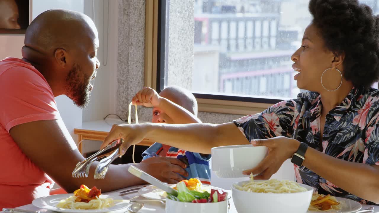 Famiglia che mangia a tavola in una casa confortevole 4k