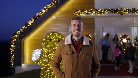festive christmas scene with a man in front of a decorated house