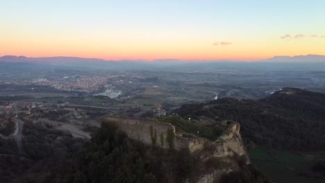 Aerial-view-historic-and-medieval-castle-ruins-on-a-cliff-at-sunset