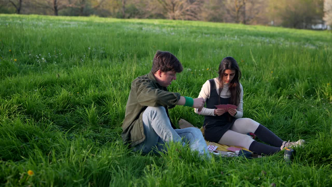 Couple playing cards in a park