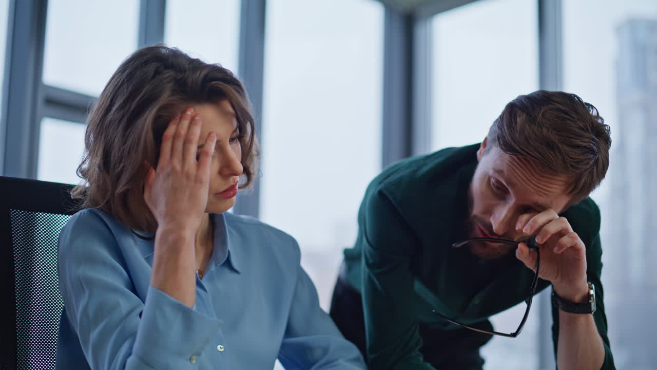 Sad employees disappointed mistake project looking laptop at workplace closeup