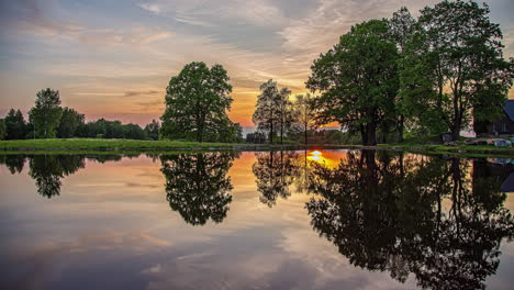 Sunset-across-the-lake-with-the-colorful-sky-reflecting-off-the-mirror-like-surface-of-the-water---time-lapse