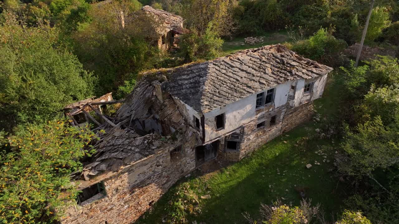 Aerial of decaying houses covered in tangled greenery, Bulgaria