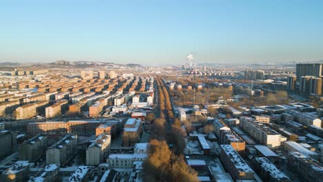 La-Vista-Aérea-Captura-La-Encantadora-Puesta-De-Sol-Invernal-En-La-Ciudad-De-Zibo,-Provincia-De-Shandong,-China,-Y-Revela-Una-Escena-Cautivadora-Adornada-Por-La-Silueta-De-Las-Plantas-De-Energía-En-El-Fondo.