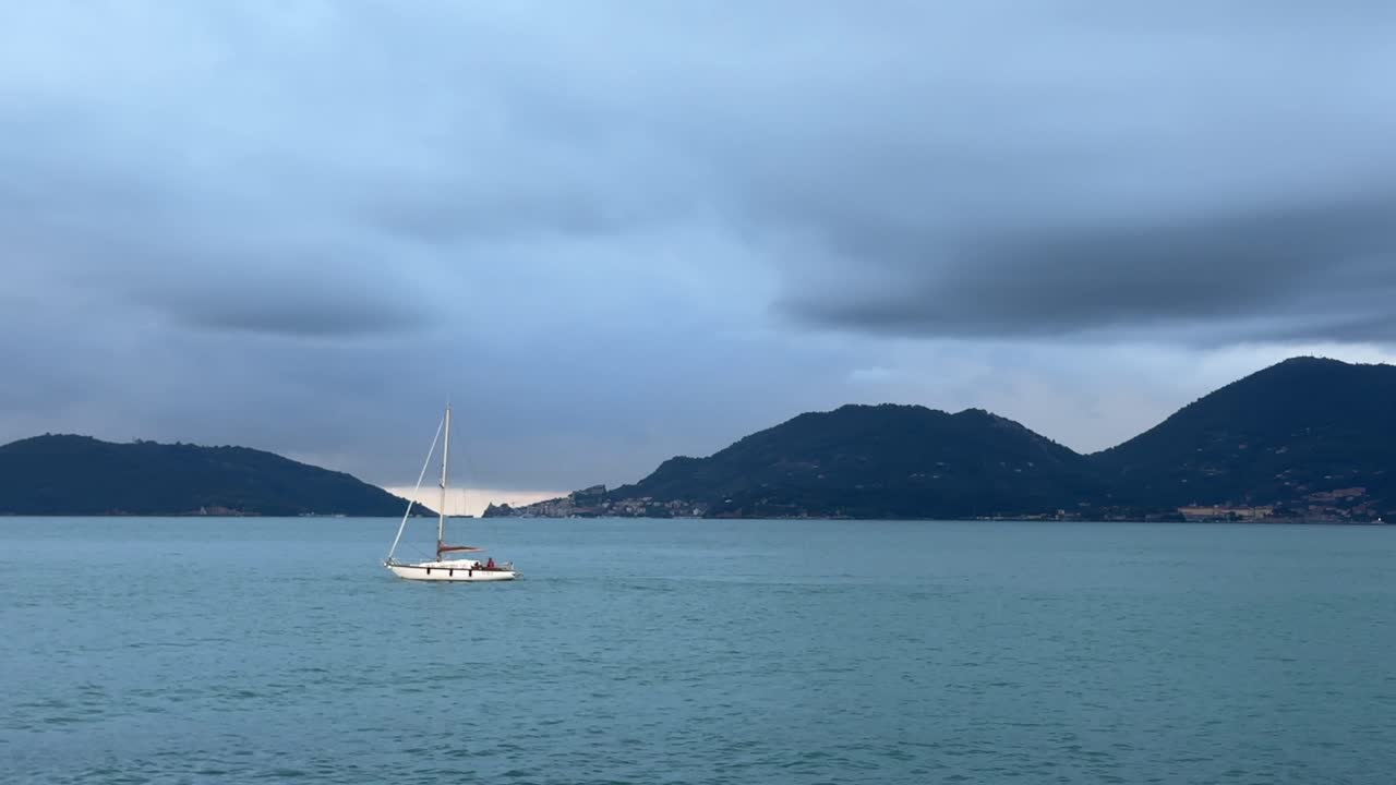 Sail Boat out at sea with dark and gloomy sky