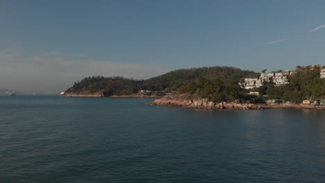 Aerial-view-of-a-coastal-village-located-in-a-beautiful-ocean-bay