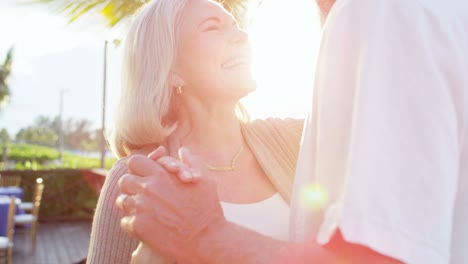 loving retired caucasian couple dancing at vacation resort