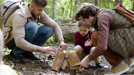 Family-holding-logs-for-campfire