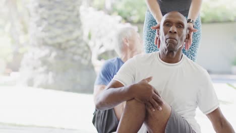focused diverse seniors exercising in pilates class with female coach, unaltered, in slow motion