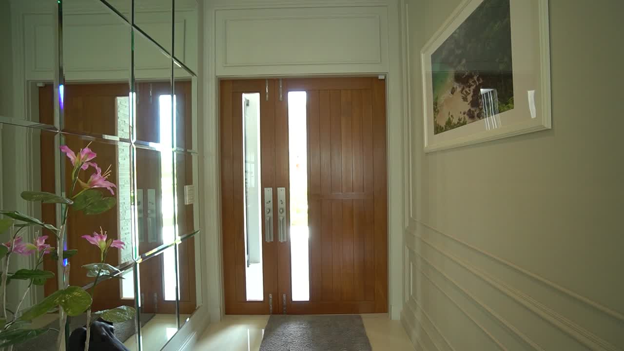 Elegante grande porta in legno in un corridoio con parete a specchio
