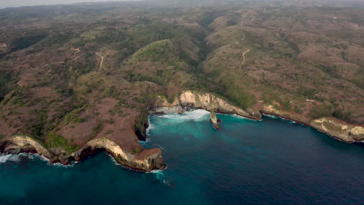 vista aérea de las olas del océano turquesa rompiendo la costa de la playa rota famoso lugar turístico en la isla de nusa penida, indonesia