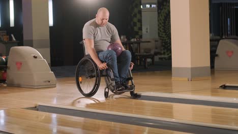 two young disabled men in wheelchairs playing bowling in the club