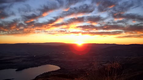 beautiful sunrise with warm colors and clouds on top of roy's peak above lake wanaka, in new zealand