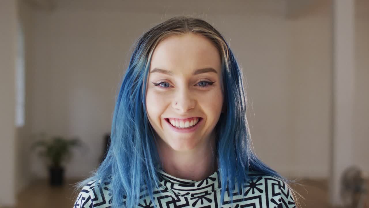 retrato de una mujer caucásica feliz mirando a la cámara en un estudio de baile, cámara lenta
