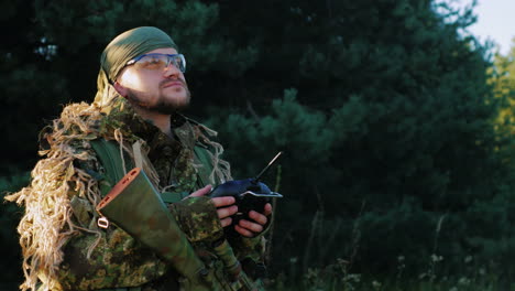 armed men in camouflage uses a remote control looking up