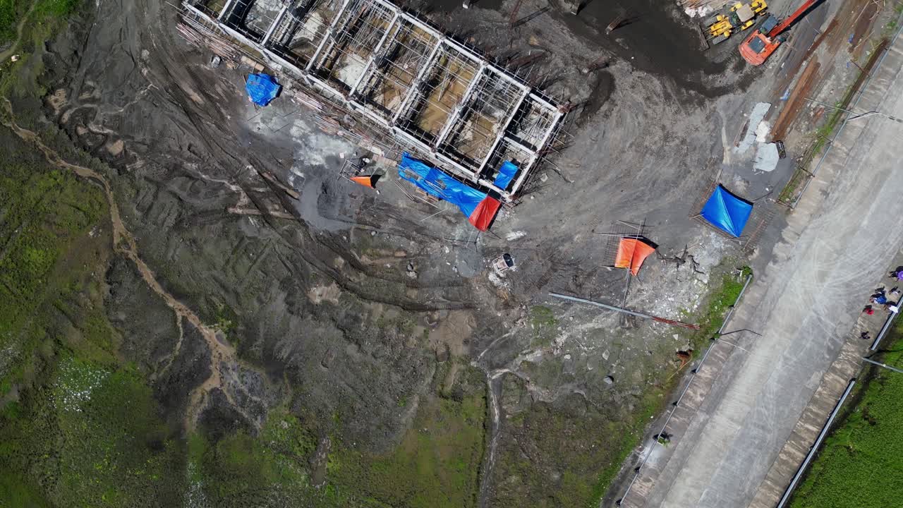 Aerial View Of Construction Site With Building Foundations And Heavy Machinery At Work. topdown revealing shot
