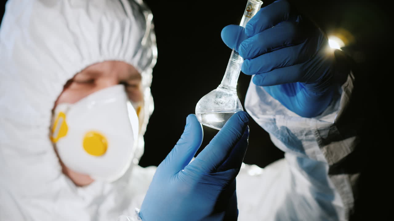 técnico de laboratorio con traje protector comprueba la calidad del agua