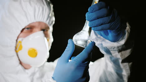 laboratory technician in a protective suit checks water quality