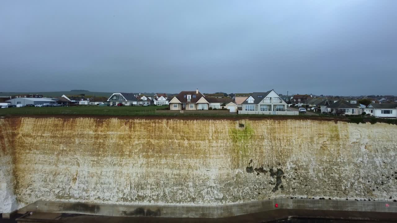 Cinematic aerial shot Brighton sea wall defences and chalk cliff, UK