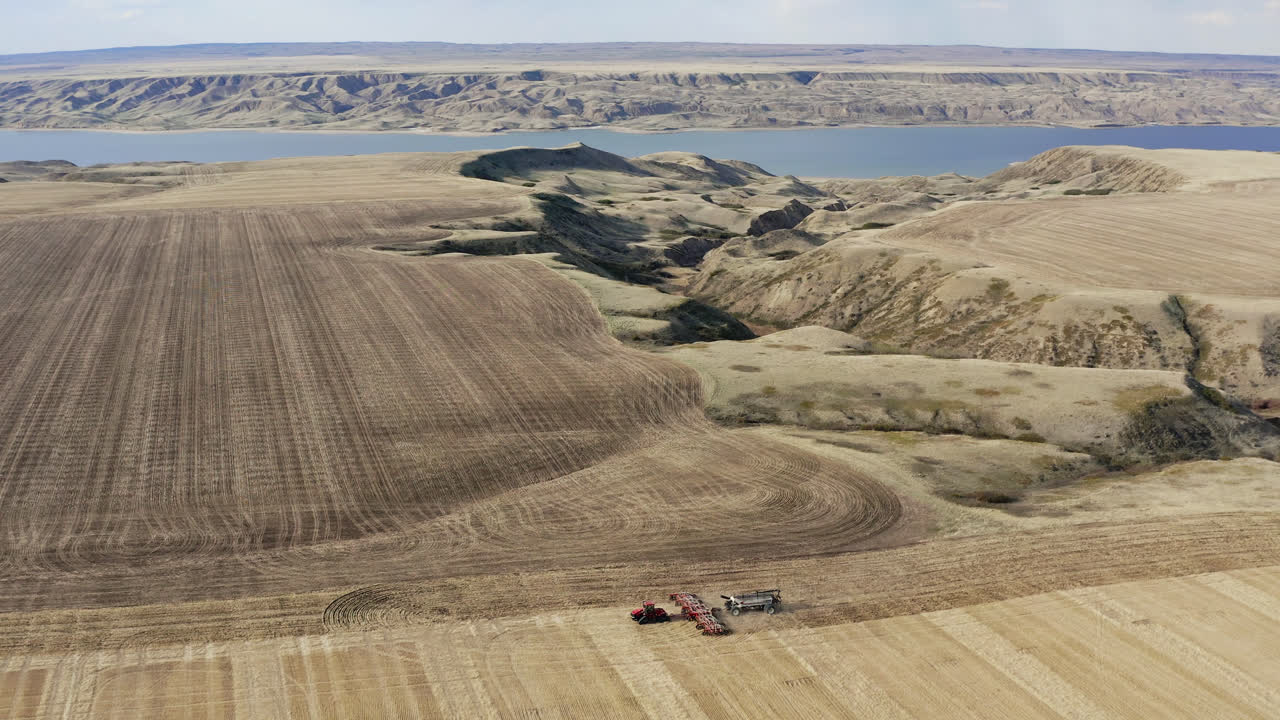 낮에 잘 익은 작물을 파종하는 파종기가 장착된 트랙터