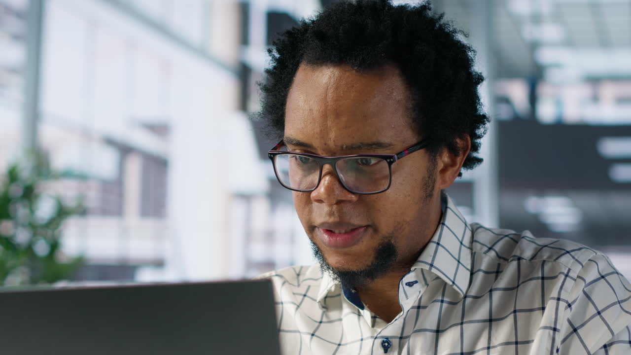 African American man working on a laptop in an office