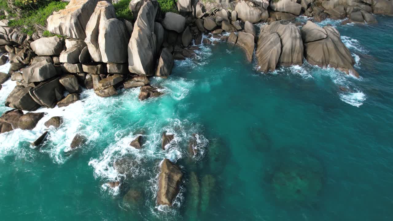 Ripresa aerea con drone della spiaggia di North East Point, enormi massi di roccia con onde che si infrangono e acqua turchese, Mahe Seychelles 30fps 2.
