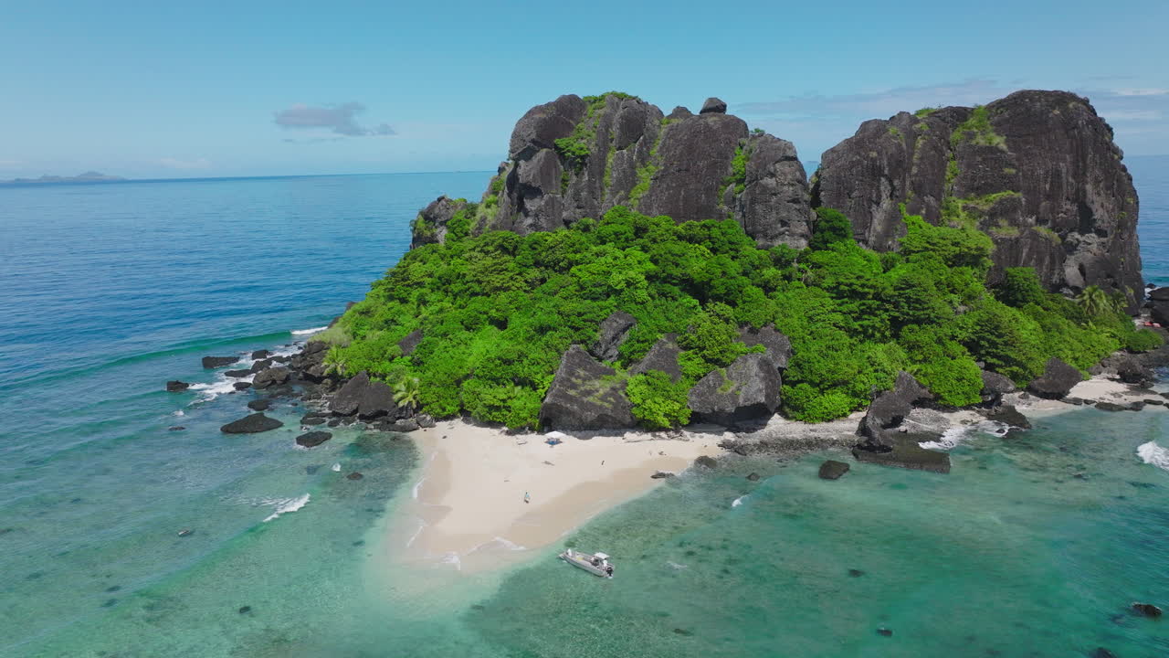 Tropical island with shallow reef and white sand edges in crystal blue water