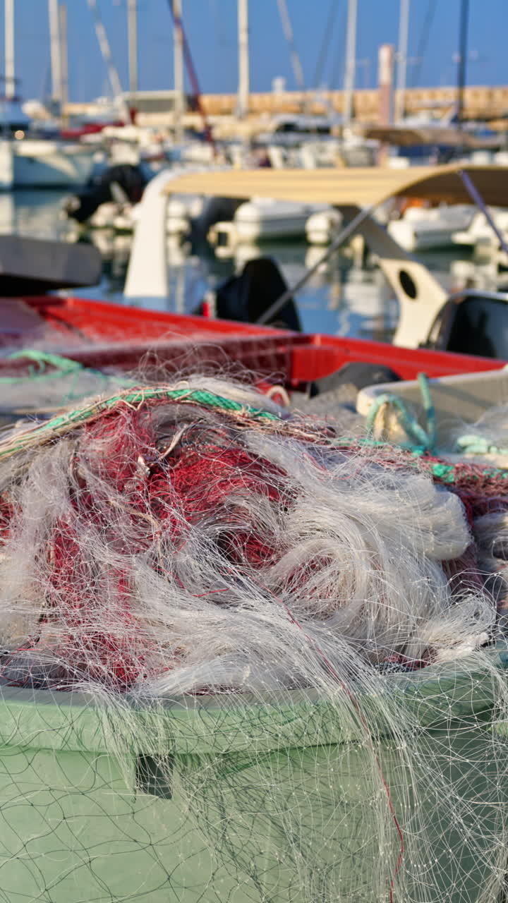 Close up of fishing nets on a docked boat in Port Vauban in daylight. Vertical