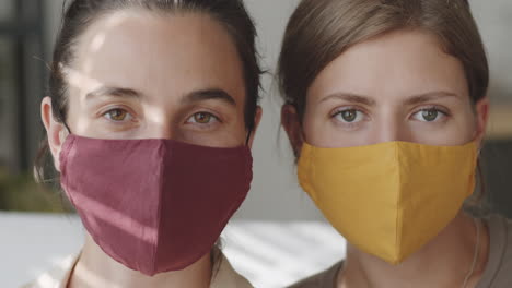 retrato de dos mujeres con máscaras de protección en casa