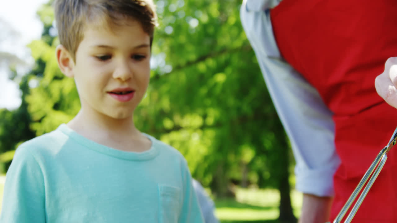 padre e hijo preparando comida en la barbacoa