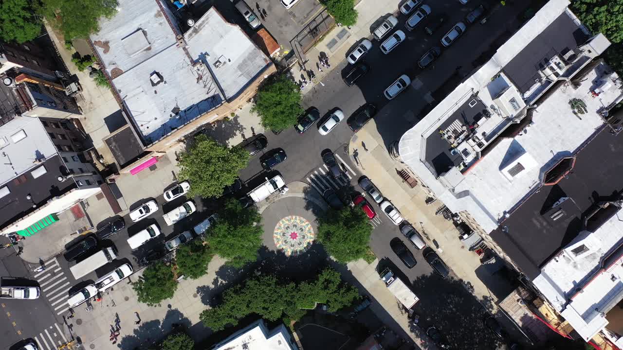 Vista dall'alto di un bellissimo e colorato mosaico creato sul marciapiede vicino a Marcy Avenue a Brooklyn, NY. Il drone parte dall'alto e scende rapidamente verso l'opera d'arte in una giornata di sole.