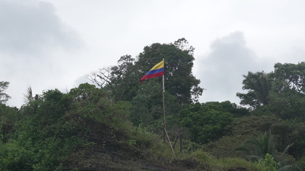 On a jungle hillside, Colombia’s tricolor ripples above Juanchaco’s coast, Low angle